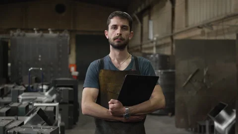 Confident industrial worker posing in a metal factory Stock Footage 334723056