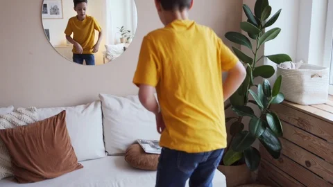 Confident kid looking at his muscles in mirror imagining that he is super hero Video stock 104240490