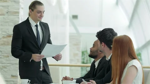 Confident leader distributes documents during a dynamic meeting Vídeo Stock 311806912