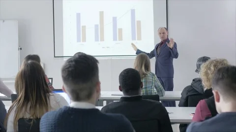 Confident lecturer speaking in front of college students in the classroom Stock Footage