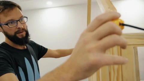 Confident man assembling childish double bed measure size measuring tape ecology Stock Footage 233470115