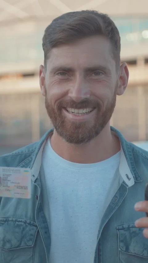 A Confident Man with a Beard Dressed in Casual Attire Stands Against an Urban Stock Footage 314959355