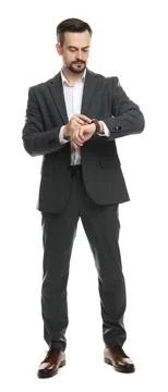 Confident man in classic suit checking time on white background Stock Photos