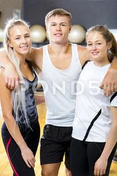 Confident Man With Female Friends Standing In Gym Stock Photos