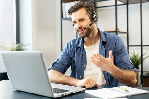 Confident man with headset talking in front of computer Foto stock