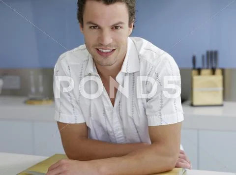 Confident Man Leaning At Kitchen Counter Stock Photos