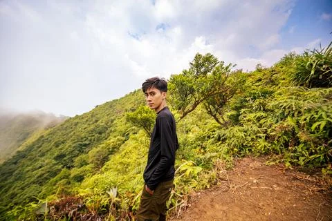 Confident Man Posing at Mountain Summit. Stunning Nature Views from the Summi Foto stock