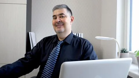 Confident Man Smiling at Camera While Working on Computer Stock Photos