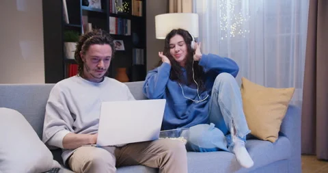 Confident man trying to finish remote work at home while his girlfriend in Stock Footage 244143125