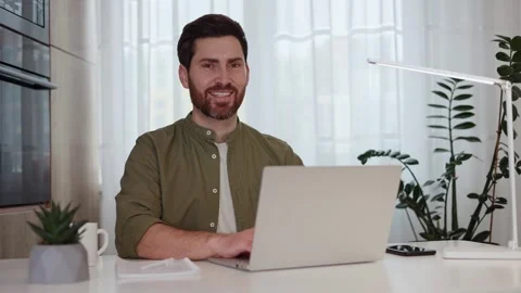 Confident man using laptop and smiling at camera during remote work at home Stock-Footage 262459767
