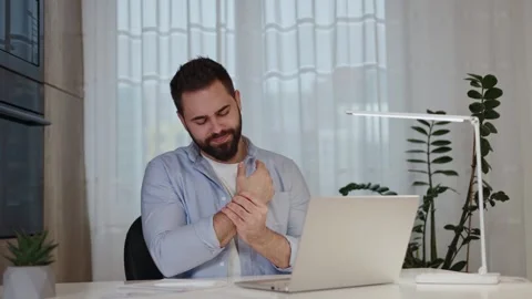 Confident man warming up palms in front of computer in light apartment Stock-Footage 265214058
