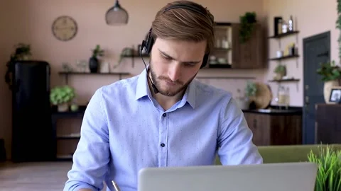 Confident man wearing headset speaking and watching business webinar training. Vidéo 131953840