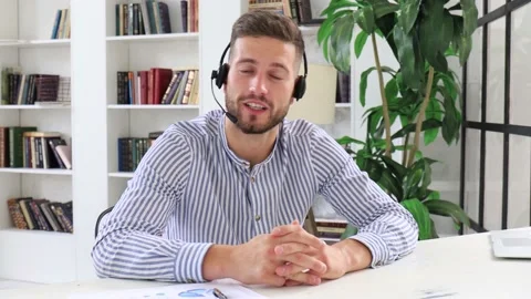 Confident man wearing headset speaking and watching business webinar training. Stock Footage 137884686