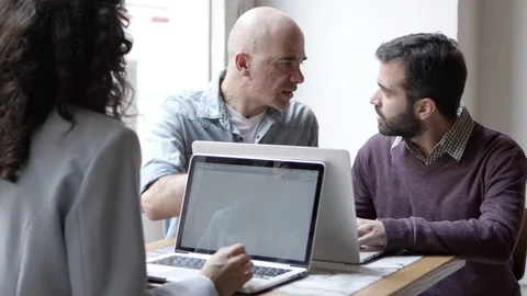 Confident managers discussing new project with laptops Stock-Footage 121003324