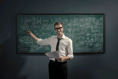 Confident math professor teaching in front of the chalkboard Stock Photos