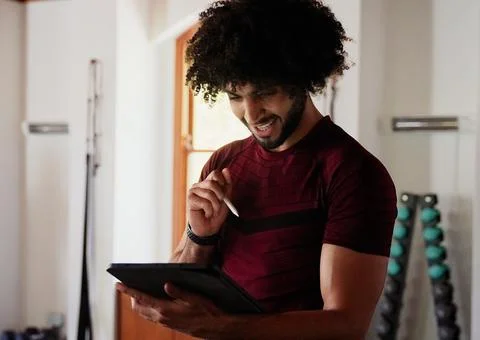 Confident middle eastern young man using digital tablet at the gym Stock Photos