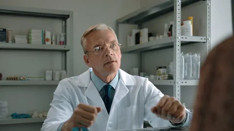 Confident pharmacy worker advises a woman's client about medications Video stock 140619624
