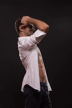Confident posing young man abs fit slim unbuttoned shirt side view Stock Photos
