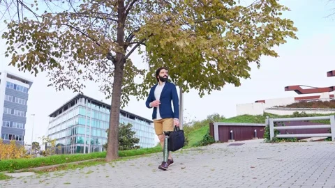 Confident Prosthetic-Legged Man Walking on a Cobbled Park Path Stock Footage 264035477