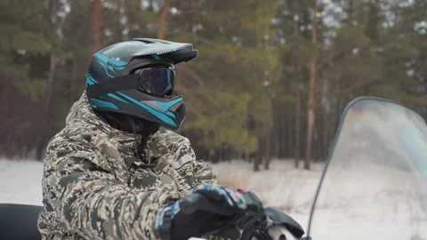 Confident rider on ATV navigating scenic snowy forest paths. Rider dressed in Video stock 345146617