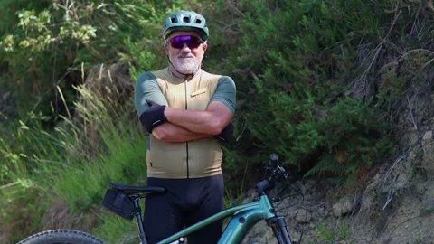Confident senior cyclist posing with his electric mountain bike Stock Footage 312067580