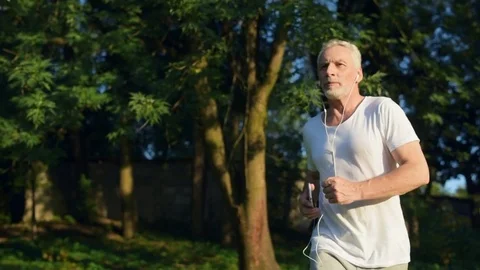 Confident senior man jogging in the park Stock Footage 80281142