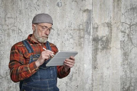 Confident senior man is making notes on tablet Foto stock