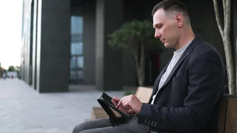 Confident serious businessman using a digital tablet outside Stock Footage 340519073