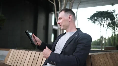 Confident serious businessman using a digital tablet outside Stock Footage 340519120
