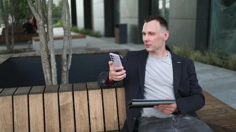 Confident serious businessman using a digital tablet outside Stock Footage 340519129