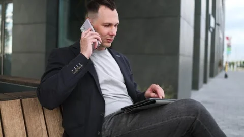 Confident serious businessman using a digital tablet outside Stock Footage 340519168
