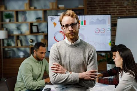 Confident smiling ginger guy, startup team leader, standing in front of mixed Stock Photos