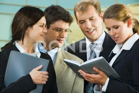Confident smiling professionals are discussing a conditions of contract on the Stock Photos