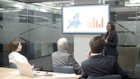 Confident speaker gesturing and looking at screen with charts Stock Footage 125431031