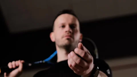 Confident Squash Player Tosses Ball with Racket Resting on Shoulder Indoors Stock Footage 313273651