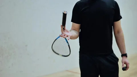 Confident squash stance with racket toss in hand - focused warm-up moment - 4K Stock Footage 308720985
