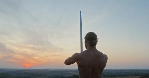 Confident strong man training with sword in nature during sunset Stock-Footage 126109650