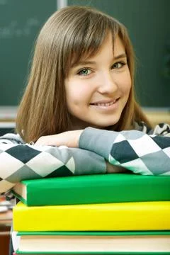 Confident student with stack of books looking at camera Foto stock