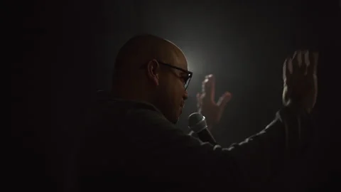 Confident successful speaker man talking and goodbye on stage with spotlight. Stock-Footage 241089228