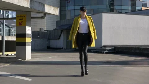 Confident supermodel with high heels walks on the roof of parking lot, feminist Stock Footage 130270995