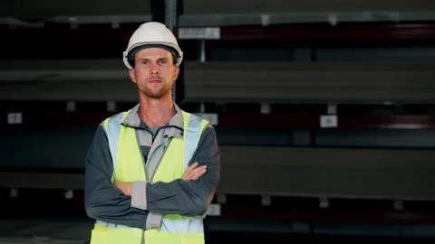 Confident Warehouse Worker Standing With Arms Crossed. Stockbeeldmateriaal 345012504