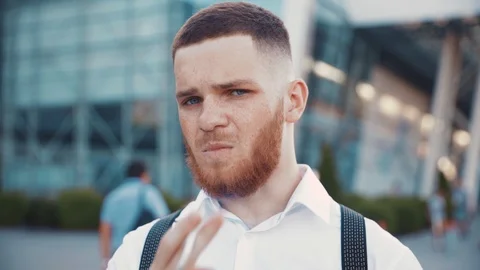 Confident well-dressed man with beard brutally smoking cigarette and looking Stock Footage 115668984