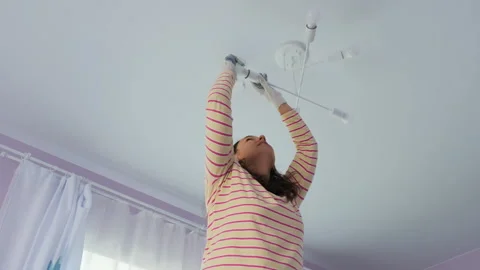 Confident woman on ladder changing light bulb Video stock 317321953