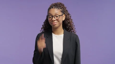 Confident woman tapping temple with a knowing smile. Studio portrait on a violet Stock Footage 341700976