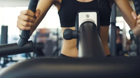 Confident woman training on a exercise machine at the gym Stock Footage 128572367