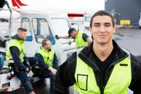 Confident Worker Standing While Colleagues Communicating At Gang 写真素材