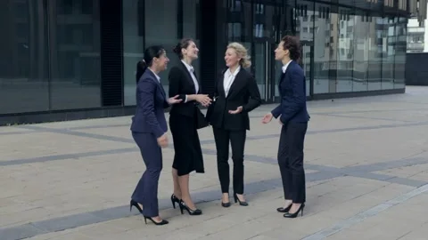 Confident workers standing making jokes, businesswomen having fun laughing on Stock Footage 135694884