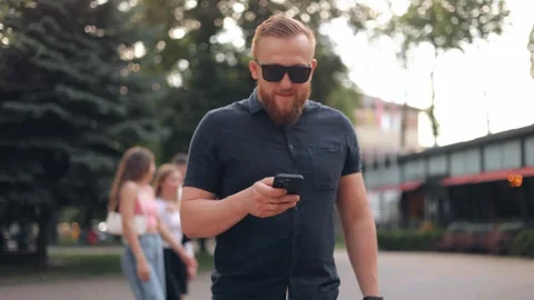 Confident young bearded man using mobile phone in modern urban area Stock Footage 244245922