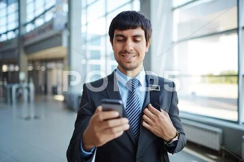 Confident young businessman reading sms in his smartphone Stock Photos