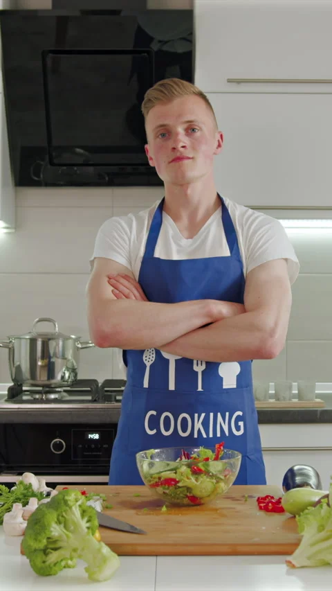 Confident young chef prepares fresh salad in bright kitchen Stock Footage 341761623